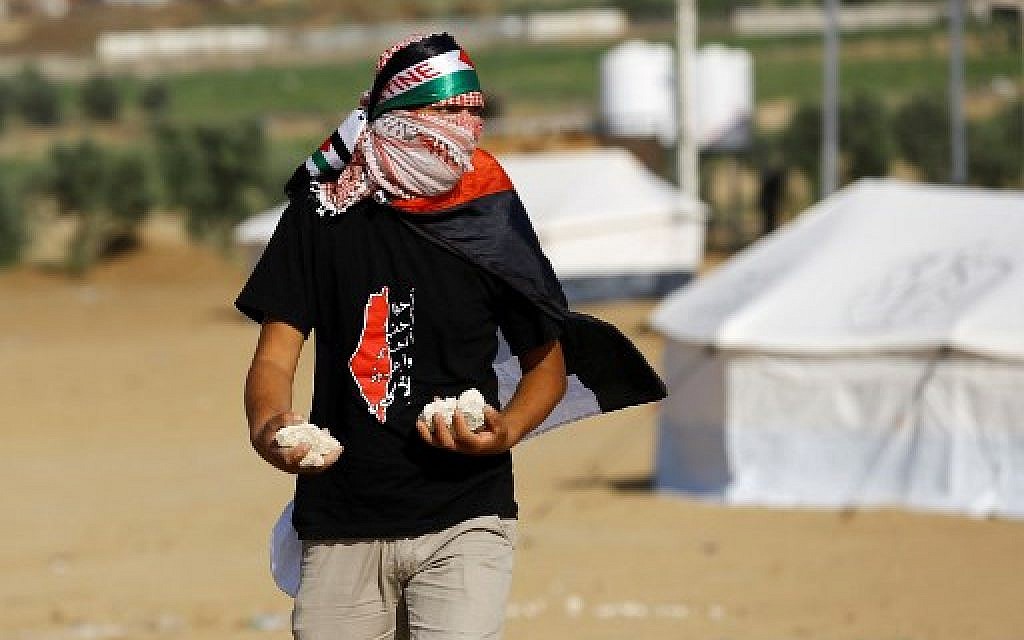 A Palestinian man holds stones east of Gaza City on May 14, 2018. (AFP Photo/Mahmud Hams)