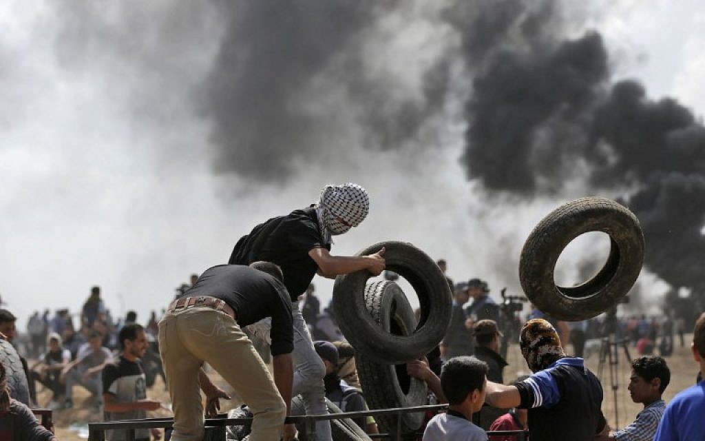 Palestinian demonstrators burn tires near the Gaza-Israel border, east of Gaza City, during protests over the inauguration of the US embassy in Jerusalem, May 14, 2018 (AFP Photo/Mahmud Hams)