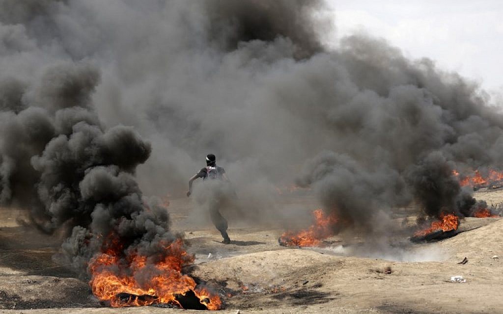 Palestinian demonstrators burn tires near the Gaza-Israel border, east of Gaza City, during protests over the inauguration of the US embassy in Jerusalem, May 14, 2018 (AFP Photo/Mahmud Hams)