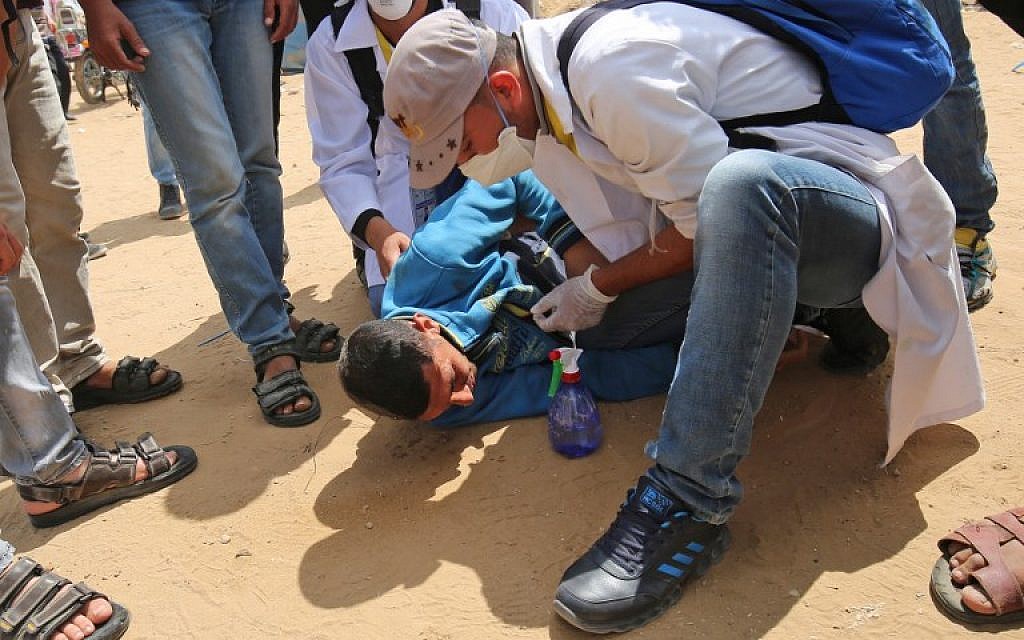 Palestinians help a protester during clashes wit Gaza-Israel border, east of Khan Yunis on May 14, 2018 (AFP PHOTO/SAID KHATIB)