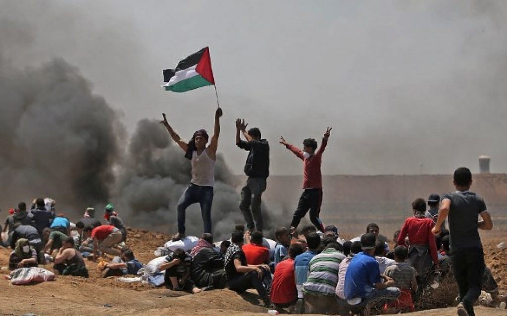 Palestinians wave their national flag as they demonstrate near the border between Israel and the Gaza Strip, east of Jabaliya, on May 14, 2018. (AFP PHOTO / MOHAMMED ABED) Palestinians wave their national flag as they demonstrate near the border between Israel and the Gaza Strip, east of Jabaliya, on May 14, 2018. (AFP PHOTO / MOHAMMED ABED)