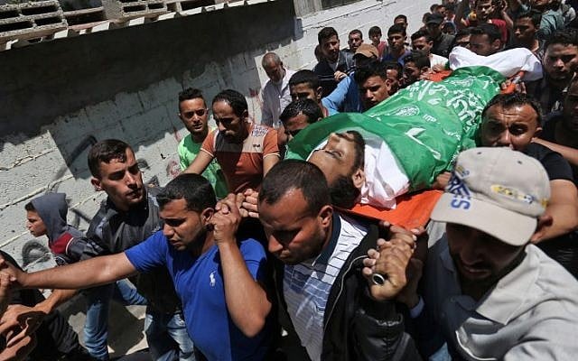 Mourners carry the body of Mohammed Dwedar a 27 year-old Palestinian killed during clashes along the Gaza border the previous day, during his funeral in Nusseirat refugee camp in the Gaza Strip on May 15, 2018. (AFP PHOTO / MOHAMMED ABED)