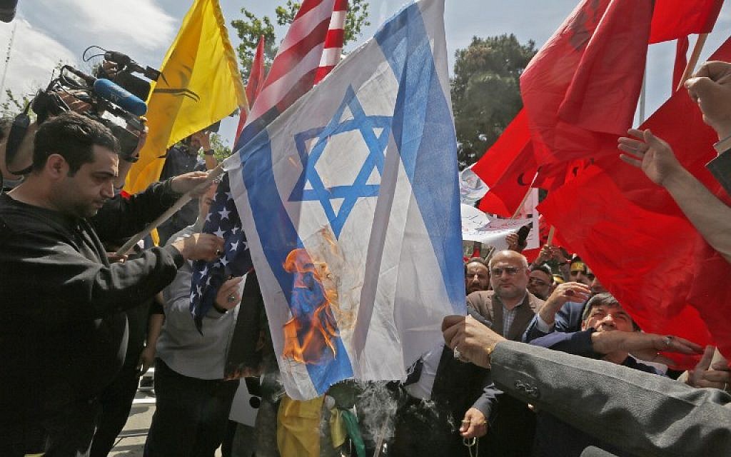 Iranians burn US and Israeli flags during a demonstration inside the former US embassy headquarters in the capital Tehran on May 16, 2018. (AFP/ ATTA KENARE)