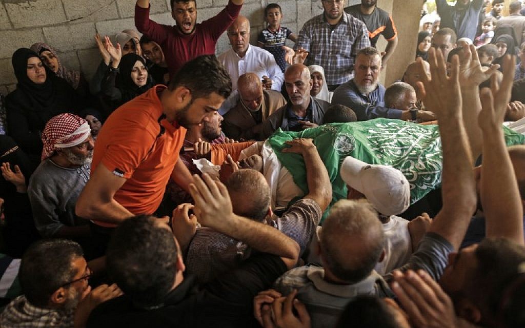 Palestinian mourners carry the body of 51-year-old Nasser Ghorab during his funeral in al-Nusirat refugee camp in the central Gaza Strip on May 16, 2018. (AFP/MAHMUD HAMS)