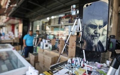 A picture taken on May 17, 2018 shows the face of Iraqi Shiite cleric and leader Muqtada al-Sadr adorning the plastic cover of a cell phone, on display at a peddlar's stall in a market street in the capital Baghdad. (AFP/AHMAD AL-RUBAYE)