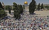 Muslim worshippers pray near the Dome of the Rock and the Al-Aqsa Mosque, located on the Temple Mount compound in Jerusalem, during the first Friday prayers of the holy month of Ramadan on May 18, 2018 (AFP Photo/Ahmad Gharabli)