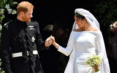 Britain's Prince Harry, Duke of Sussex and his wife Meghan, Duchess of Sussex leave from the West Door of St George's Chapel, Windsor Castle, in Windsor, on May 19, 2018 after their wedding ceremony. (AFP/ Ben Birchall)