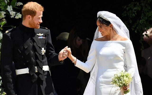 Britain's Prince Harry, Duke of Sussex and his wife Meghan, Duchess of Sussex leave from the West Door of St George's Chapel, Windsor Castle, in Windsor, on May 19, 2018 after their wedding ceremony. (AFP/ Ben Birchall)
