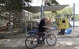 An Israeli man walks past a kindergarten yard, after mortar shells fired from the Gaza Strip exploded near it, in the southern Israeli Kibbutz of Ein Hashlosha on May 29, 2018. Palestinian terrorists in the Gaza Strip fired a barrage of mortar shells at southern Israel on Tuesday, the army said, causing no injuries but raising tensions in the border area. (AFP PHOTO / JACK GUEZ)