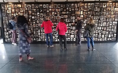 A Holocaust memorial created in the 'sauna' facility of the former German Nazi death camp Auschwitz-Birkenau, in Poland, with photographs of people deported there, October 2017 (Matt Lebovic/The Times of Israel)