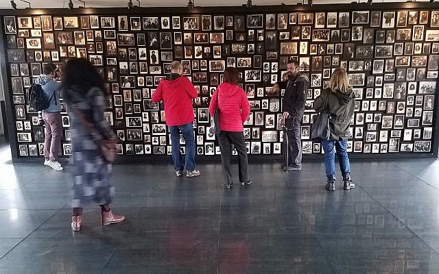 A Holocaust memorial created in the 'sauna' facility of the former German Nazi death camp Auschwitz-Birkenau, in Poland, with photographs of people deported there, October 2017 (Matt Lebovic/The Times of Israel)