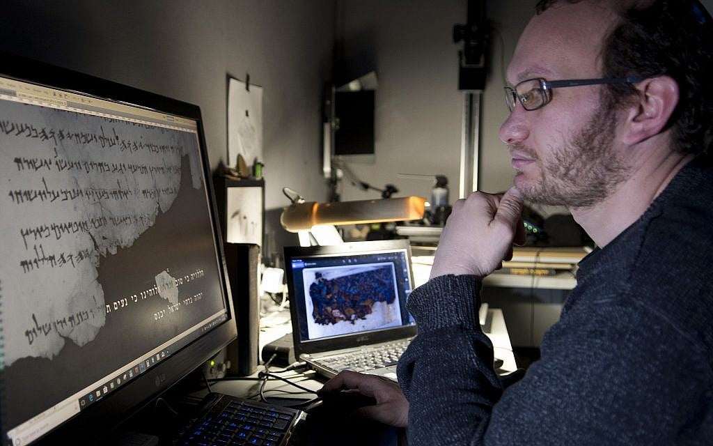 Oren Ableman, scroll researcher at the Dead Sea Scrolls unit of the Israel Antiquities Authority, examining the ink traces that have been discovered. (Shai Halevi, The Leon Levy Dead Sea Scrolls Digital Library)