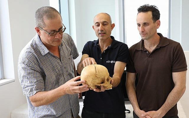 Researchers who are studying the first evidence of blood vengeance, discovered in a cave in the Jerusalem Hills. From left to right: Prof. Boaz Zissu Dr. Yossi Nagar and Dr. Haim Cohen with the skull (Chen Galili/Israel Antiquities Authority) Researchers who are studying the first evidence of blood vengeance, discovered in a cave in the Jerusalem Hills. From left to right: Prof. Boaz Zissu Dr. Yossi Nagar and Dr. Haim Cohen with the skull (Chen Galili/Israel Antiquities Authority)