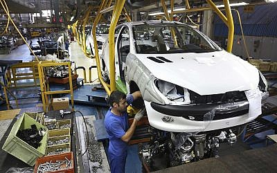 An Iranian worker assembles a Peugeot 206 at the state-run Iran-Khodro automobile manufacturing plant near Tehran, Iran, 11, 2014. (AP Photo/Ebrahim Noroozi, File)