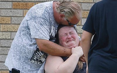 A man hugs a woman outside the Alamo Gym where parents wait to reunite with their children following a shooting at Santa Fe High School in Santa Fe, Texas, on Friday, May 18, 2018. (Michael Ciaglo/Houston Chronicle via AP)