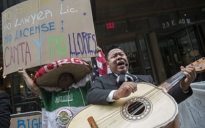 A demonstrator dances and sings along the Mariachi Tapatio de Alvaro Paulino band as they perform during a demonstration across the street from the building that once housed the office space of Aaron Schlossberg, Friday, May 18, 2018, in New York. (AP /Mary Altaffer)