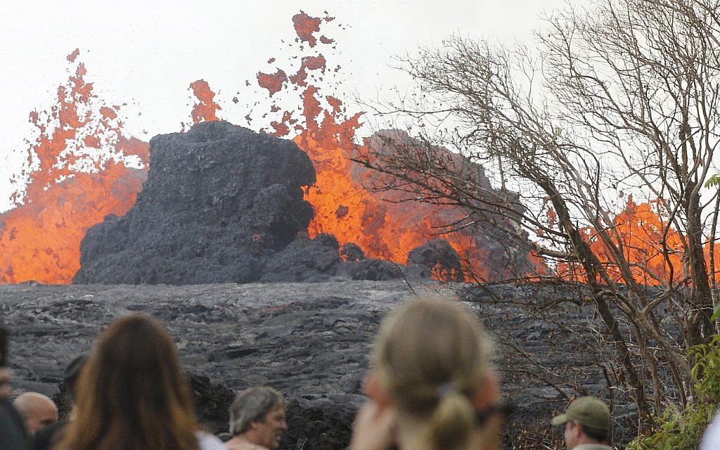 In a May 26, 2018 photo, area residents, the media and national guard flock to what is now the end of Leilani Avenue to take in the fiery show at fissures 2, 7 and 8 of the Kilauea volcano near Pahoa. (George F. Lee/The Honolulu Advertiser via AP)