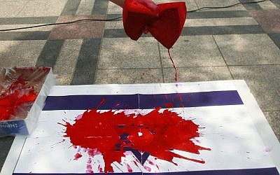 Illustrative photo of an Israeli flag daubed with red paint. (Ahn Young-joon/AP)