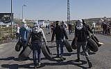 File: Masked Palestinian protesters carry tires to be set on fire, during clashes with Israeli troops, at the northern entrance of the West Bank city of Ramallah, March 12, 2018 (AP Photo/Nasser Nasser)