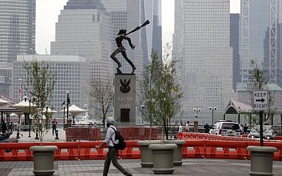 A man walks in front of a statue dedicated to the victims of the Katyn massacre of 1940, Friday, May 4, 2018, in Jersey City, N.J.  (AP Photo/Julio Cortez)
