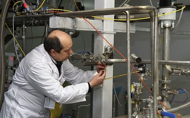 Illustrative: An unidentified International Atomic Energy Agency inspector cuts the connections between the twin cascades for 20 percent uranium enrichment at the Natanz facility, some 200 miles (322 kilometers) south of the capital Tehran, Iran, January 20, 2014. (AP/IRNA, Kazem Ghane)