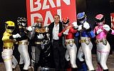 Haim Saban, center, creator of Power Rangers and Chairman and CEO of Saban Capital Group, poses with the Rangers outside the Bandai booth at the American International Toy Fair, Sunday, February 10, 2013, in New York. (Diane Bondareff/Invision for Saban Brands/AP)