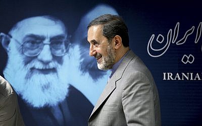 Iranian official Ali Akbar Velayati, a former foreign minister, walks past a portrait of supreme leader Ayatollah Ali Khamenei at the conclusion of his press conference in Tehran, Iran, June 3, 2013. (AP Photo/Ebrahim Noroozi)