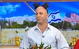 Still from video of a comedy sketch by the Eretz Nehederet satire show depicting Education Minister Naftali Bennet wearing joke tefillin, May 16, 2018. (Screen capture: Hadashot news)