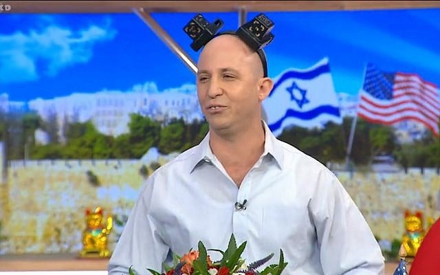 Still from video of a comedy sketch by the Eretz Nehederet satire show depicting Education Minister Naftali Bennet wearing joke tefillin, May 16, 2018. (Screen capture: Hadashot news) Still from video of a comedy sketch by the Eretz Nehederet satire show depicting Education Minister Naftali Bennet wearing joke tefillin, May 16, 2018. (Screen capture: Hadashot news)