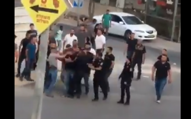 A screenshot from video reporting to show a police officer slapping an arrested suspect in the face during a violent confrontation between police and residents of the southern city of Rahat on May 25, 2018. (Screen capture: Twitter) A screenshot from video reporting to show a police officer slapping an arrested suspect in the face during a violent confrontation between police and residents of the southern city of Rahat on May 25, 2018. (Screen capture: Twitter)