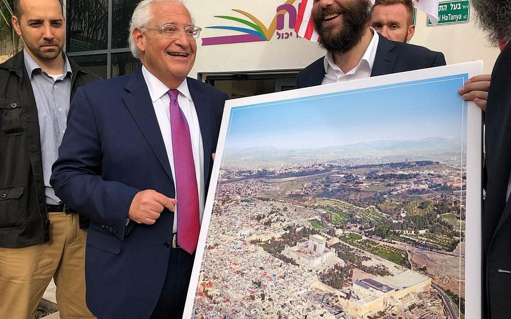 US Ambassador to Israel David Friedman is pictured next to a man holding a poster of the Jewish Temple replacing the Muslim Dome on the Rock on Jerusalem's Temple Mount, at an event for the Achiya educational nonprofit in Bnei Brak, May 22, 2018. (Courtesy: Kikar HaShabbat) US Ambassador to Israel David Friedman is pictured next to a man holding a poster of the Jewish Temple replacing the Muslim Dome on the Rock on Jerusalem's Temple Mount, at an event for the Achiya educational nonprofit in Bnei Brak, May 22, 2018. (Courtesy: Kikar HaShabbat)