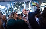 Jerusalem Mayor Nir Barkat seen taking a selfie with Jerusalemites as he tours "First Train Station" in Jerusalem on March 24, 2015. (Miriam Alster/Flash90)