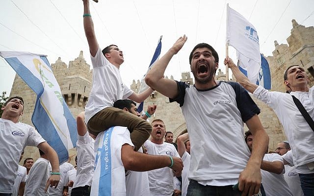 Thousands of Israelis  wave the Israeli flags as they celebrate Jerusalem Day by dancing through Damascus Gate on their way to the Western Wall.  on May 13, 2018. (Yonatan Sindel/Flash90