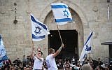 Thousands of Jewish marchers wave the Israeli flags as they celebrate Jerusalem Day by dancing through Damascus Gate on their way to the Western Wall in the Old City of Jerusalem, May 13, 2018. (Yonatan Sindel/Flash90)