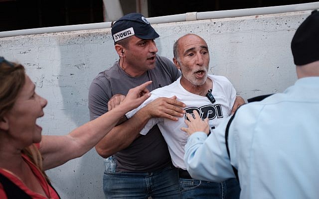Police officers detain an activist during a protest of disabled people and activists, calling for better health care and allowances in Tel Aviv on May 31, 2018. (Tomer Neuberg/Flash90) Police officers detain an activist during a protest of disabled people and activists, calling for better health care and allowances in Tel Aviv on May 31, 2018. (Tomer Neuberg/Flash90)