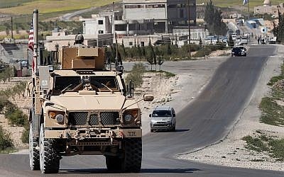 A US soldier sits on an armored vehicle on a road leading to the tense front line in Manbij, north Syria, Wednesday, April 4, 2018. (AP/Hussein Malla)