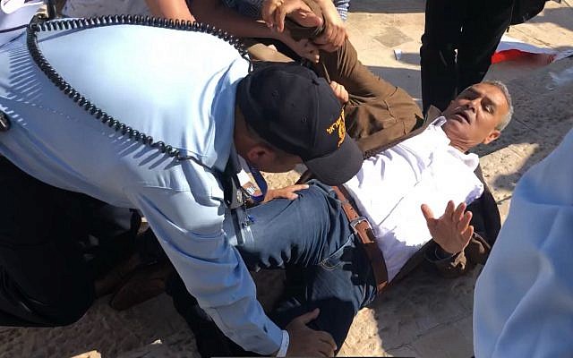 Joint List MK Jamal Zahalka is pushed to the ground by Israeli police officers outside the new US embassy in Jerusalem as the ceremony to inaugurate the building was held on May 14, 2018. (Joint List/courtesy) Joint List MK Jamal Zahalka is pushed to the ground by Israeli police officers outside the new US embassy in Jerusalem as the ceremony to inaugurate the building was held on May 14, 2018. (Joint List/courtesy)