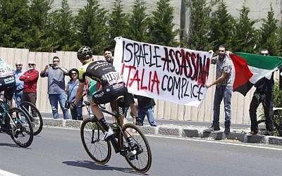 Anti-Israel protesters hold a banner reading 'Israel assassinates, Italy complicit' before the start of the 4th stage of the Giro d'Italia cycling race between Catania and Caltagirone in Sicily, May 8, 2017. (AFP PHOTO / Luk Benies)