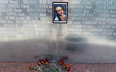 Flowers are placed under a picture of 41-year-old anti-Kremlin reporter Arkady Babchenko on the memorial wall of Moscow's journalists house on May 30, 2018, until his death was revealed to have been faked. (AFP PHOTO / Vasily MAXIMOV)