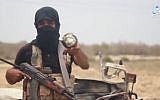 A member of the Islamic State's Sinai affiliate purporting to show Israeli-made munitions found in the rubble of an airstrike in a video released by the Amaq news agency on May 23, 2018. (screen capture, Amaq)