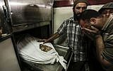 A Palestinian man mourns near the body of Mohammed al-Radeia, 30, prior to his funeral in Beit Lahia in the northern Gaza Strip on May 28, 2018. The Palestinian man was killed by Israeli tank fire into northern Gaza earlier in the day, the health ministry in the Hamas-run enclave said. An Israeli army spokeswoman told AFP that two Palestinian men tried to breach the border fence "with the intention of carrying out an attack." (AFP PHOTO / MAHMUD HAMS)