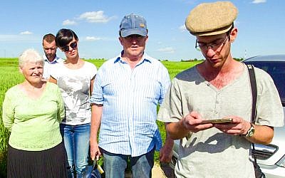 Amit Hirsch, right, recites the mourner's prayer at what used to be the Jewish cemetery in Turobin, Poland, June 2017. (Courtesy of Lea Hirsch)