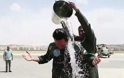 Jordanian Crown Prince Hussein ibn Abdullah gets the traditional celebratory treatment of a bucket of water over the head after his first solo helicopter flight. (Twitter)