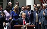 President Donald Trump, flanked by members of faith-based communities, signs a proclamation declaring a National Day of Prayer during an event in the Rose Garden at the White House, May 3, 2018. (Mark Wilson/Getty Images, via JTA)
