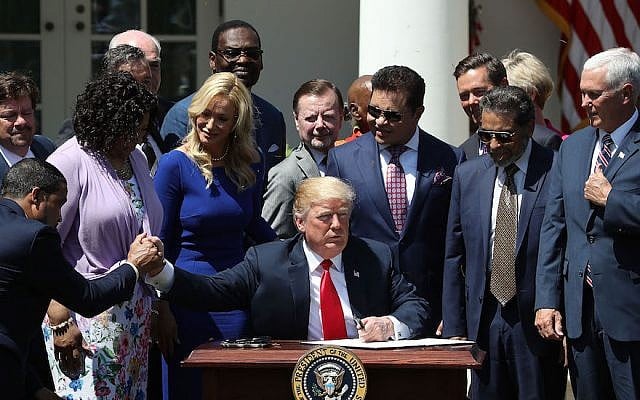 President Donald Trump, flanked by members of faith-based communities, signs a proclamation declaring a National Day of Prayer during an event in the Rose Garden at the White House, May 3, 2018. (Mark Wilson/Getty Images, via JTA) President Donald Trump, flanked by members of faith-based communities, signs a proclamation declaring a National Day of Prayer during an event in the Rose Garden at the White House, May 3, 2018. (Mark Wilson/Getty Images, via JTA)