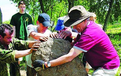 Dr. Michael Lozman, foreground, fixing up a Jewish cemetery in Belarus. (Courtesy)