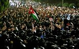 Members of the Jordanian gendarmerie and security forces stand on alert as protesters shout slogans and raise a national flag during a demonstration outside the Prime Minister's office in the capital Amman late on June 2, 2018. (AFP PHOTO / Khalil MAZRAAWI)