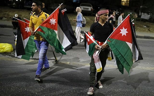 Demonstrators carry Jordanian flags during a protest near the prime minister's office in Amman, Jordan, on June 6, 2018. (AFP PHOTO / AHMAD GHARABLI) Demonstrators carry Jordanian flags during a protest near the prime minister's office in Amman, Jordan, on June 6, 2018. (AFP PHOTO / AHMAD GHARABLI)