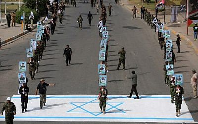 Iran-allied Shiite paramilitary fighters step on an Israeli flag drawn on the pavement during a rally to mark "Quds Day" (Jerusalem Day) first initiated by Iran in 1979 to fall on the last Friday of the holy month of Ramadan, in the Iraqi capital Baghdad on June 8, 2018. (AFP/Ahmad al-Rubaye)