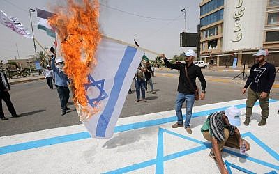 Shiite fighters of paramilitary units burn an Israeli flag drawing during a rally to mark  al-Quds Day em), a commemoration first initiated by Iran in 1979 to fall on the last Friday of the holy month of Ramadan, in the capital Baghdad on June 8, 2018. / AFP PHOTO / AHMAD AL-RUBAYE